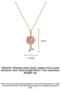 Macro view of gold titanium necklace featuring a pink flower pendant and leaf detail