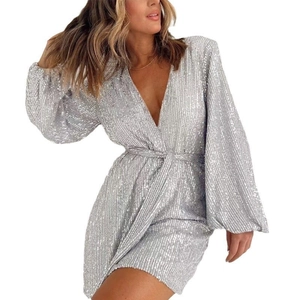 Detailed view of silver sequin dress featuring puff sleeves and an elegant waist tie