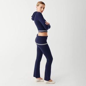 Detail of ribbed knit fabric texture on a navy blue two-piece crop hoodie and flare pants set