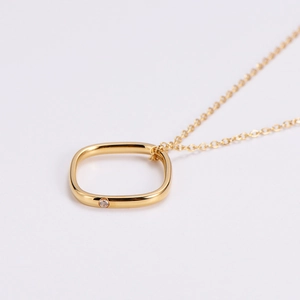 Minimalist gold geometric necklace featuring a rounded rectangle pendant with a single diamond