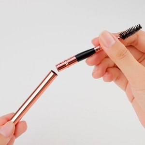 Portable rose gold dual-ended eyelash and eyebrow brush with detachable metal handle