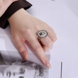 Detail of silver stainless steel ring with concentric circles and pavé-set zircons
