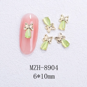 Nail art charms featuring green teardrop cat-eye stones in gold frames, 6x10mm size detail