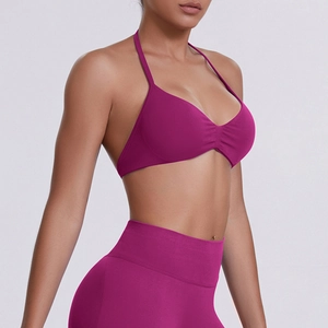 Detail of fuchsia halter sports bra and high-waisted yoga leggings with seamless finish