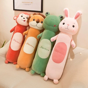 Row of cute monkey, lion, frog and rabbit long plush pillows on a beige sofa