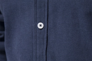 Close-up of navy blue slim fit shirt showing fabric texture and white button detail