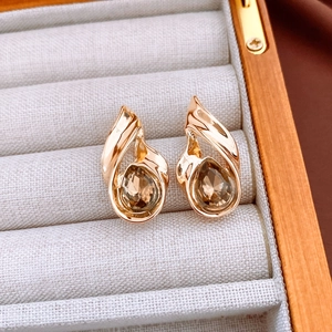 Detail of vintage gold drop earrings with brown teardrop gems in a jewelry box