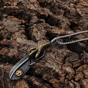 Ciondolo piuma vintage e artiglio d'aquila in argento su sfondo in corteccia
