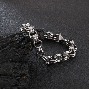 Close-up of silver punk O-link chain bracelet on a dark textured stone background