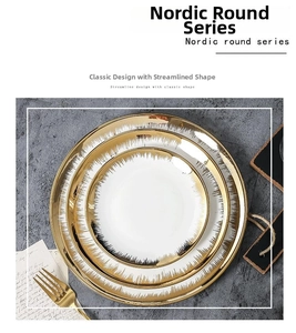 Three-piece stackable white ceramic plates with gold rims on a textured grey background