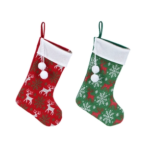 Detail of red and green knitted Christmas stockings with reindeer and snowflake patterns