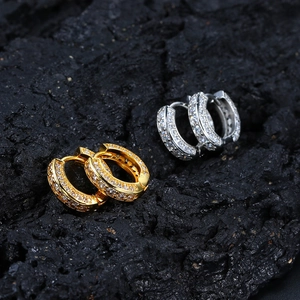 Macro shot of gold and silver hoop earrings with clear pavé zircon on black rock background