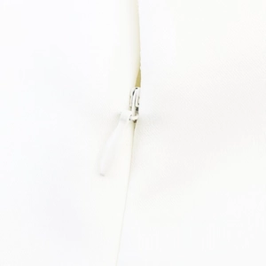 Detailed close-up of the hidden zipper closure on a white V-neck dress garment
