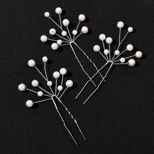 Detail of three bridal hair pins featuring white pearls and silver twisted wire branches