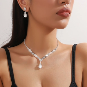 Silver teardrop necklace and earrings set with sparkling crystals on a model