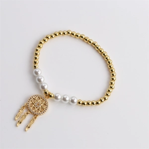 Golden beaded dreamcatcher bracelet featuring white pearls on a clean white background