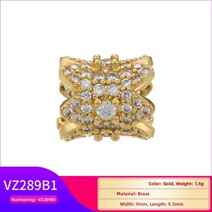 Macro detail of gold-plated brass X-shaped bead charm micro-paved with white zircon stones