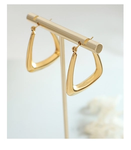 Macro shot of 18k gold plated U-shaped triangle hoop earrings with mirror finish