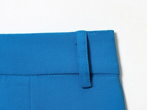 Détail de la taille du pantalon bleu cobalt avec passants de ceinture et coutures fines