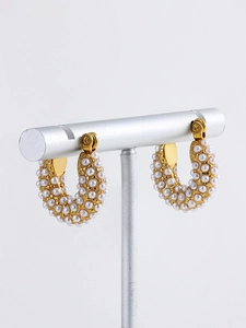 Close-up of 18K gold plated hoop earrings featuring intricate white pearl micro-paving