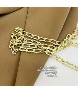 Close-up of a polished bright gold metal chain strap for stylish crossbody bags