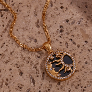 Dettaglio macro della collana in oro 18K con ciondolo sole e luna e strass bianchi brillanti