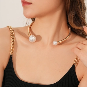 Close-up of golden metal choker necklace with large pearls on a female model