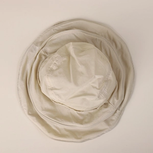 Top-down macro view of a beige quick-dry wide-brim sun hat showing soft fabric texture