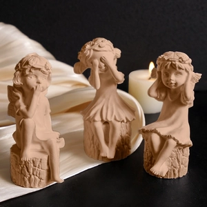 Three girl angel candle figures in see no evil hear no evil speak no evil poses on wood