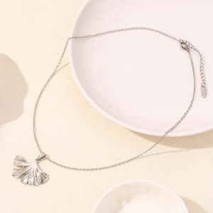 Macro detail of stainless steel ginkgo leaf pendant with delicate vein textures
