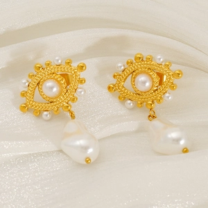 18k gold evil eye earrings with baroque pearl drop on elegant silk fabric background
