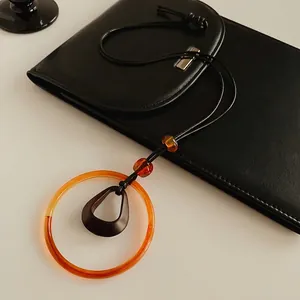 Retro wax rope long necklace with geometric amber resin circles and dark coffee rings