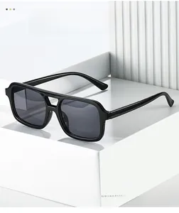 Close-up of classic black double-bridge square sunglasses on a white geometric stand