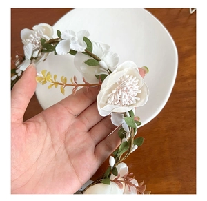 Close-up of white silk flowers and lifelike stamens on a woodland style floral headband