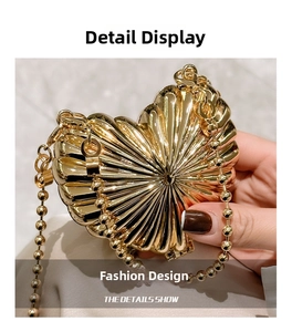 Close-up of golden heart metal clutch featuring radial shell texture and beaded chain