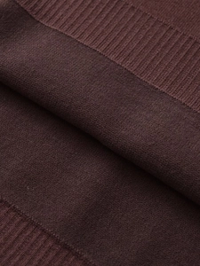Macro shot of high-quality dark brown knitted fabric with fine fiber texture details