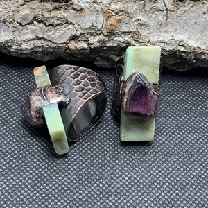 Detail of vintage bronze ring featuring snake scale texture and amethyst stones