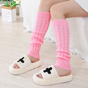 Close-up of pink cable knit leg warmers with cozy winter texture and soft yarn detail
