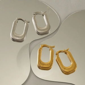 Detailed shot of textured rectangular 18K stainless steel earrings in gold and silver
