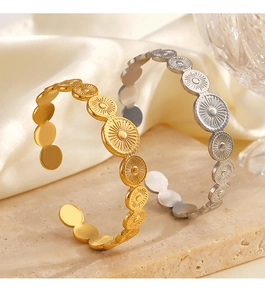 Detailed shot of gold and silver geometric circular bangles on a stone surface