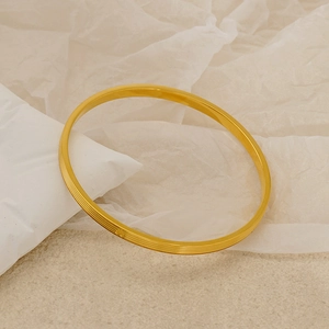Close-up of gold-plated titanium steel bracelet featuring parallel textured stripe details