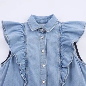 Detail van lichtblauwe mouwloze denim top met ruches en knoopsluiting aan de voorkant