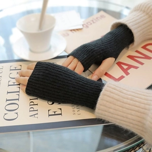 Close-up of black fingerless knitted gloves with a cozy winter lifestyle aesthetic