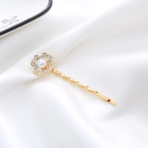 Elegant gold flower hair clip featuring sparkling rhinestones and a white faux pearl