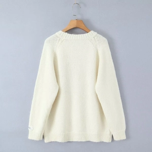 Detail of warm white mohair sweater showing soft knit texture and woven cuff label detail