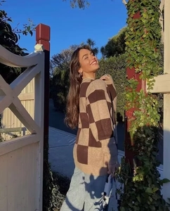 Detail of soft oversized checkered knit cardigan with brown and beige patterns