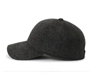 Detail view of dark grey knitted winter baseball cap with fleece lining and metal badge
