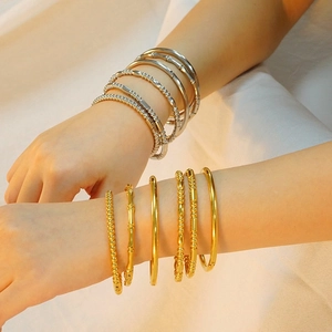 Fashionable stainless steel bead bracelets in gold and silver finish shown on a model