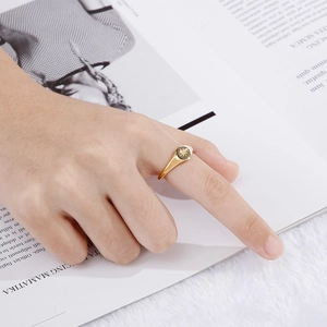 Golden stainless steel signet ring with starburst engraving worn by model on magazine