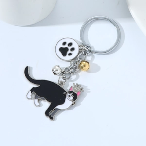 Close-up of cat keychain with crown black cat, paw pendant and golden bell charms